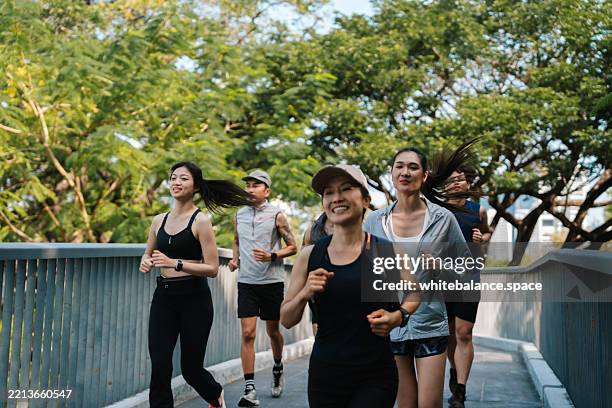 group of runners jogging together through the park, participating in their regular club activity - retreating stock pictures, royalty-free photos & images