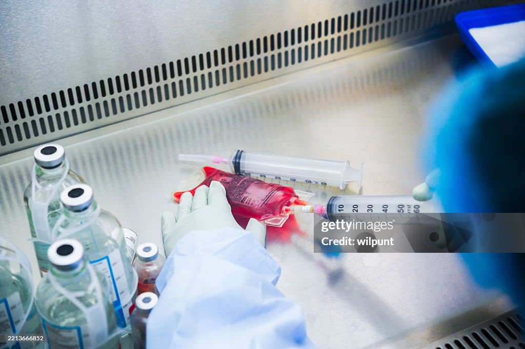 Medical procedures involving lab equipment and fluid handling in a clinical setting
