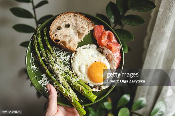 healthy breakfast with asparagus, fried egg, salmon and bread. - carbohidrato fotografías e imágenes de stock