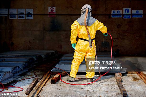 hazmat worker in protective suit disinfecting industrial metal surfaces - biohazard symbol stock pictures, royalty-free photos & images
