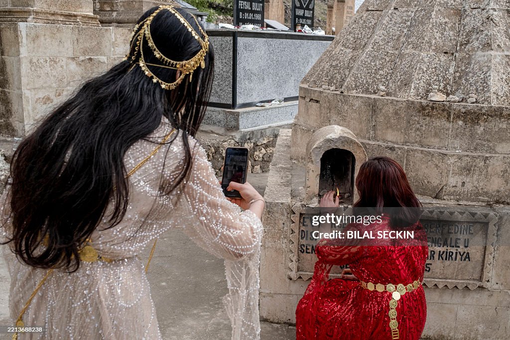 The Wednesday Ritual A Yazidi woman performs her religious ritual by lighting a candle in ...