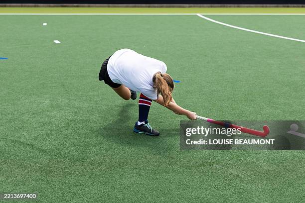 action shot of a young female field hockey player hitting a ball - field hockey stock pictures, royalty-free photos & images