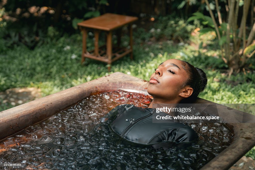 Women practicing necessary steps for ice bath therapy, pinching their noses with their fingers to hold their breath