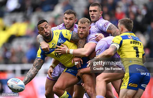 Warrington player Paul Vaughan offloads in the tackle during the Betfred Super League match between Wigan Warriors and Warrington Wolves at St James'...