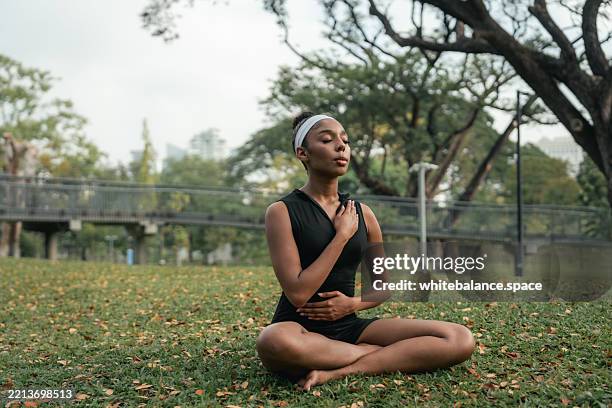 close-up shot of woman's bare feet lying on the grass, embracing the grounding and therapeutic benefits of nature - immune system stock pictures, royalty-free photos & images