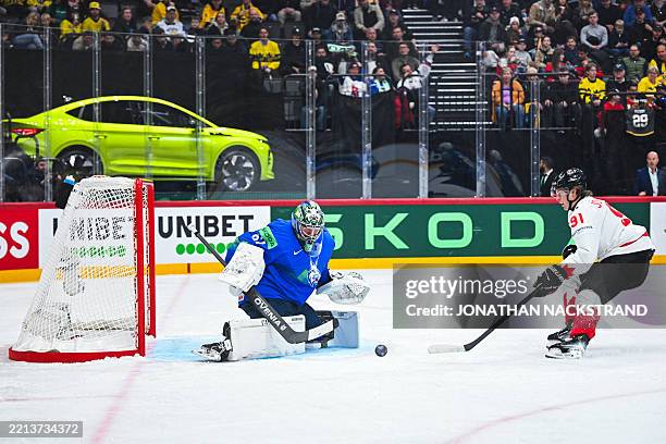 Canada's forward Kent Johnson with an attempt on Slovenia's goaltender Lukas Horak during the IIHF Men's Ice hockey World Championship match between...