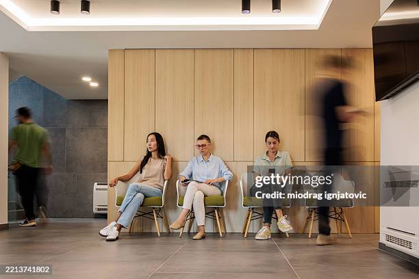 patientinnen in der lobby einer gesundheitseinrichtung - wartezimmer stock-fotos und bilder