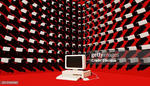 retro computer surrounded by excessive cctv cameras symbolizing surveillance and privacy concerns - spyware stock-fotos und bilder