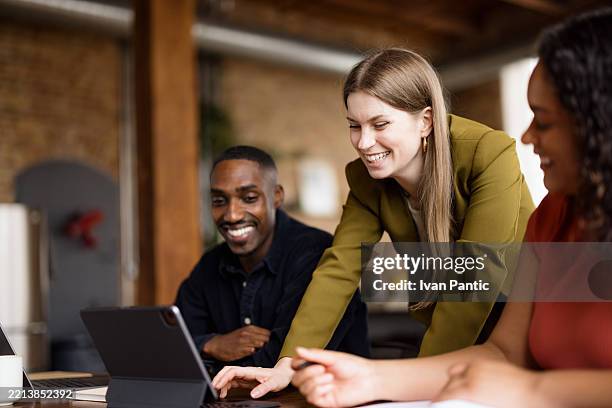 happy entrepreneurs surfing the internet on touchpad in the office. - touchpad stock pictures, royalty-free photos & images