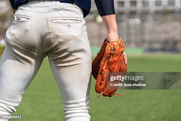 baseball player holding glove during outdoor game on green field - sports glove stock pictures, royalty-free photos & images