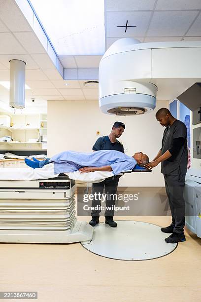 senior male patient in oncology treatment using advanced medical equipment linear accelerator - radiotherapy stock pictures, royalty-free photos & images