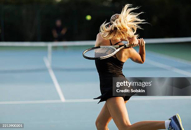 young female tennis player hitting the ball - tennis player stock pictures, royalty-free photos & images