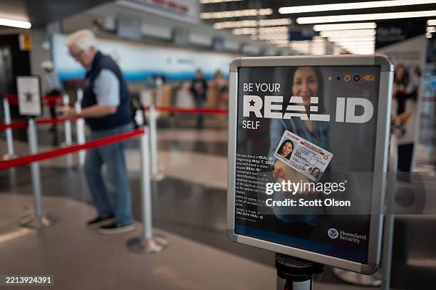 Sign notifies passengers at a security checkpoint about Real ID requirements for travel at O'Hare International Airport on May 07, 2025 in Chicago,...