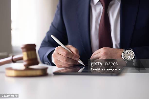 tablet digitale giudice o avvocato consulente legale che esamina e firma documenti legali. - notaio foto e immagini stock