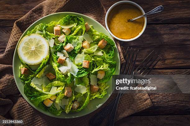 plato de ensalada césar disparado desde arriba sobre una mesa de madera rústica - ensalada verde fotografías e imágenes de stock