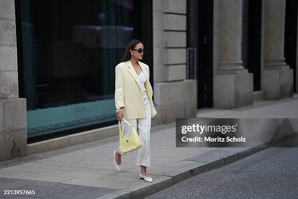 Laura Noltemeyer is seen wearing a butter yellow blazer from Zara, a knitted v-neck top in viscose crêpe in white from Drykorn, a 5-pocket wide-leg...