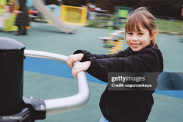 little girl playing on the merry-go-round - child dizzy stock pictures, royalty-free photos & images