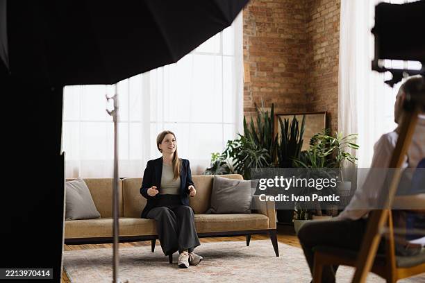 jeune femme interviewée par un journaliste dans un loft - interview photos et images de collection