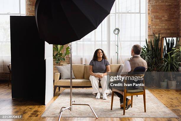 woman being interviewed by journalist in modern loft studio - theaterdecor stockfoto's en -beelden