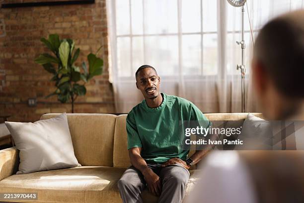 young man talking with psychologist during therapy session at home - casting actor stock pictures, royalty-free photos & images