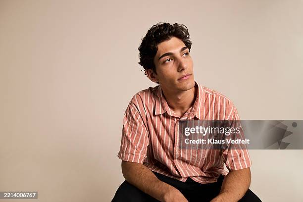 young male day dreaming against colored background - three quarter length stock pictures, royalty-free photos & images