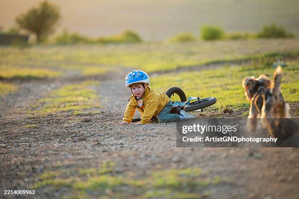 little boy is crash with balance bike on footpath. - ein junge allein stock-fotos und bilder