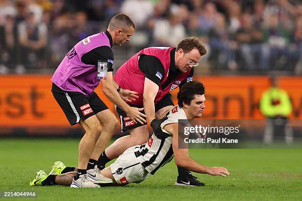 Lachie Schultz of the Magpies collapses in the hands of medical staff while walking from the field following a collision during the round nine AFL...