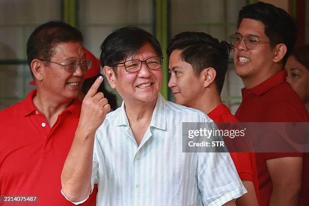 Philippine President Ferdinand Marcos shows his inked finger after voting in the mid-term election at a polling station in Batac town, Ilocos Norte...