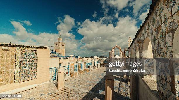 exploring historic tunisian rooftop with ornate tiles and archways - tunísia imagens e fotografias de stock