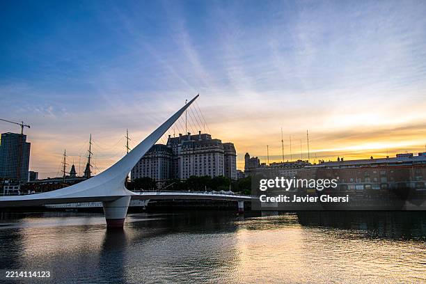 puente de la mujer (women's bridge), dam and buildings. puerto madero, buenos aires, argentina. - fußgängerbrücke-puente-de-la-mujer stock-fotos und bilder