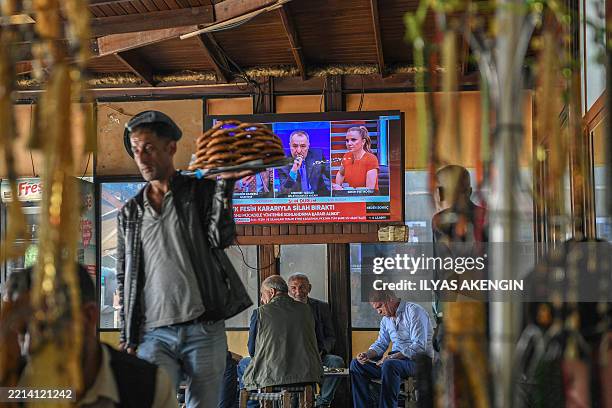 This photograph shows a screen announcing of PKK's dissolution on the News on a television screen inside a traditional Turkish tea house, in...