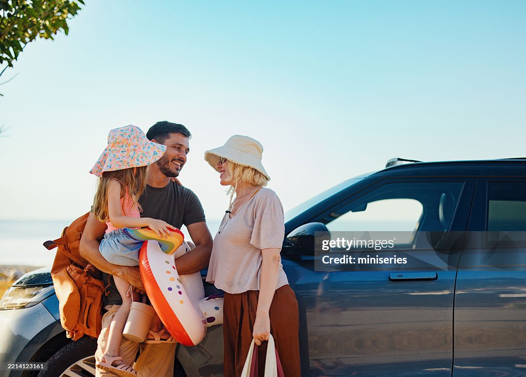 Happy Family Preparing for a Summer Vacation on a Beachside Road