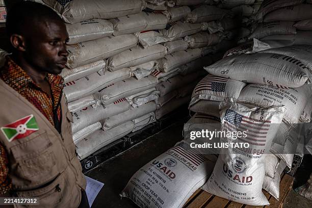 Burundian government official from the Office for the Protection of Refugees inspects sacks of the final batches of yellow peas delivered by the...