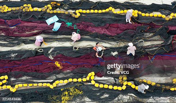 Fishermen repair fishing nets as the East China Sea has entered its annual summer fishing moratorium on May 7, 2025 in Taizhou, Zhejiang Province of...