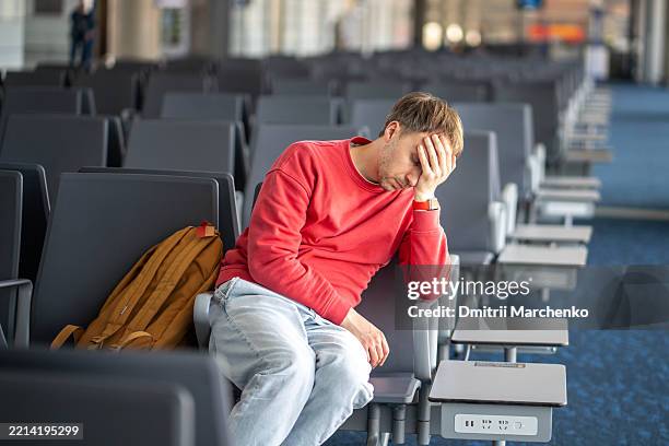 sleeping man lean forward in airport lounge after hours of waiting. long connection between flights - travel cancellation stock pictures, royalty-free photos & images
