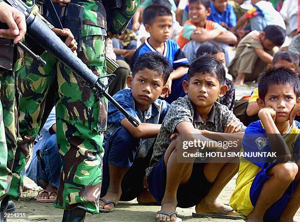 Acehnese children living at a refugee camp sit waiting to see Indonesian State Minister of Women's Empowerment Affairs Sri Redjeki during her visit...