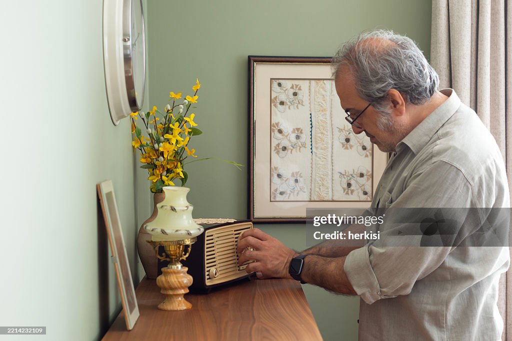 Portrait of happy senior man with his radio at living room