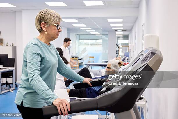 in the physiotherapy ward, the elderly woman is exercising on a treadmill. - treadmill stock pictures, royalty-free photos & images