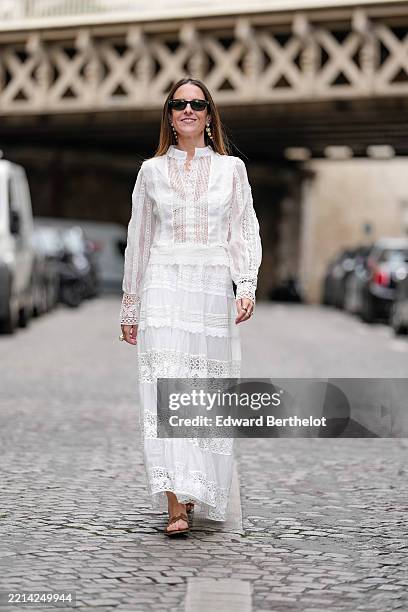 Alba Garavito Torre wears a white lace-trim Tiered blouse dress with high neckline, pintuck pleats and intricate openwork panels, paired with a...
