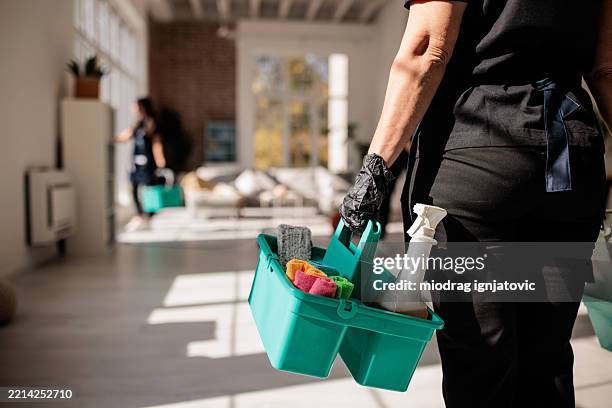 professional cleaner carrying cleaning supplies - líquido de limpeza imagens e fotografias de stock
