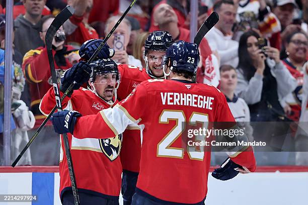 Brad Marchand of the Florida Panthers celebrates with Aleksander Barkov and Carter Verhaeghe after scoring the game winning goal against Joseph Woll...
