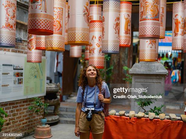 frau, die kunsthandwerk in hanoi, vietnam erkundet - kleinere sehenswürdigkeit stock-fotos und bilder