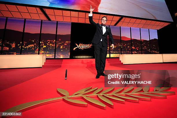Director Quentin Tarantino drops a mic on stage during the Opening Ceremony and the screening of the film "Partir un Jour" presented out of...
