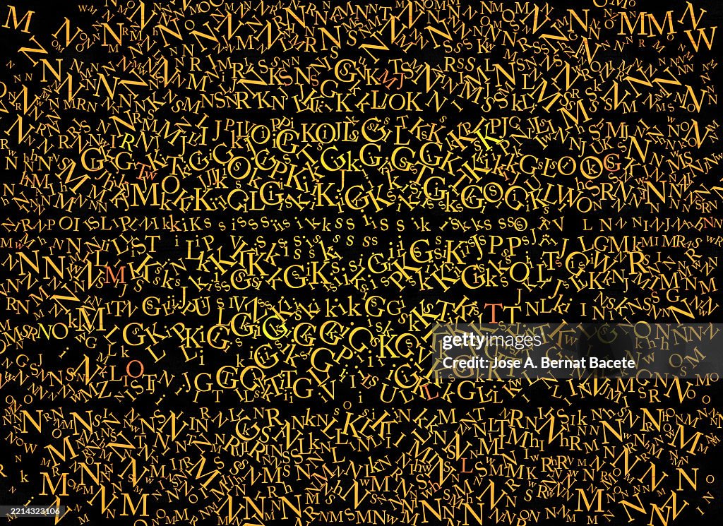 Abstract background, jumbled alphabet letters in orange tones on a black background.