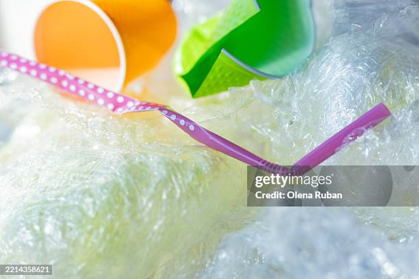 colored garbage over polyethylene cling film. - torn garbage bag stock pictures, royalty-free photos & images