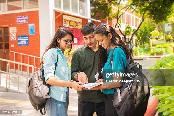 three students discussing together on a book at school campus - south asian people stock pictures, royalty-free photos & images