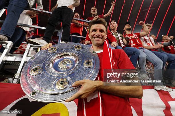 Thomas Mueller of Bayern Munich celebrates with the Meisterschale trophy after the Bundesliga match between FC Bayern München and Borussia...