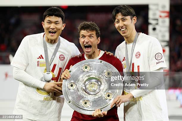 Kim Min-Jae, Thomas Mueller and Hiroki Ito of Bayern Munich pose for a photo with the Meisterschale trophy after the teams 2-0 victory in the...