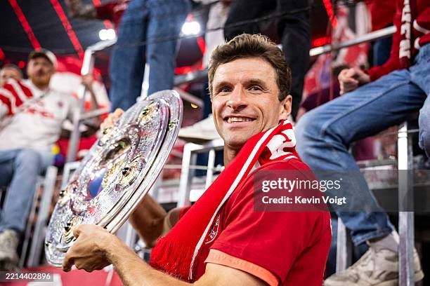 Thomas Mueller of FC Bayern Muenchen poses for a photograph as he celebrates with the Meisterschale trophy after the Bundesliga match between FC...