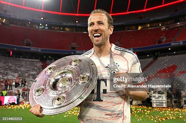 Harry Kane of Bayern Munich poses for a photo with the Meisterschale trophy and his medal after the teams 2-0 victory in the Bundesliga match between...